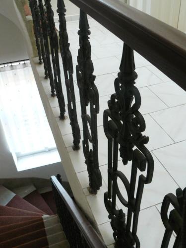a staircase with black railings and a white tile floor at Vila U Varhanáře in Kutná Hora