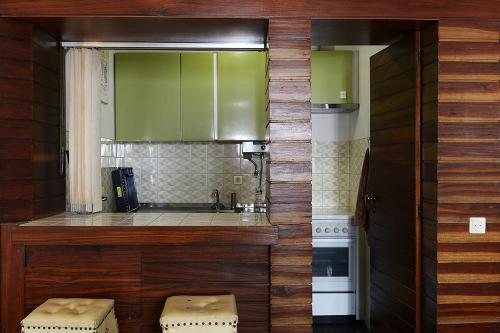 una cocina con armarios verdes y una barra con taburetes en FLH Studio Cascais, en Cascais