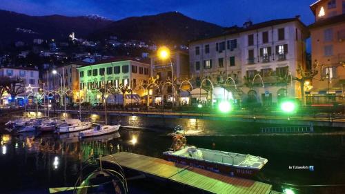 a city at night with boats in the water at Il porticciolo in Bellano