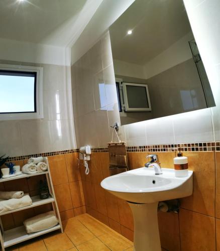 a bathroom with a sink and a mirror at Villa PANGALIS Romantica in Kato Pavliana