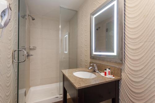 y baño con lavabo y ducha. en Travelodge by Wyndham South Hackensack en South Hackensack