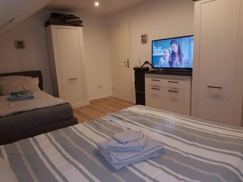 a bedroom with a bed and a flat screen tv at Ferienwohnung Rhein-Main in Flörsheim