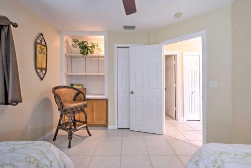 a bedroom with a chair and a table and a kitchen at Canalfront Home with Private Saltwater Pool! in Marco Island