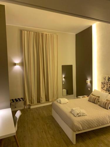 a bedroom with a bed with two towels on it at La Banchina Holiday Rooms in Trani