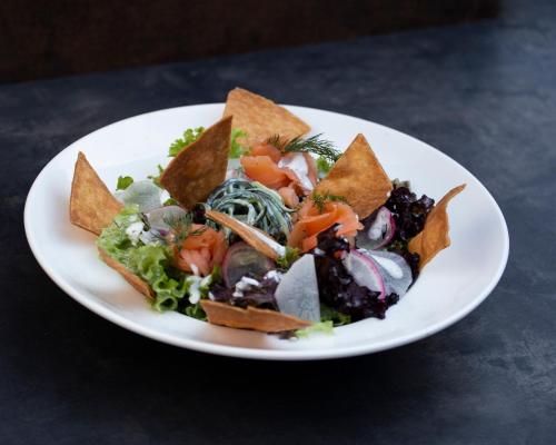 a white plate of food with a salad and chips at SALAMANDRA Hotel in Banská Štiavnica