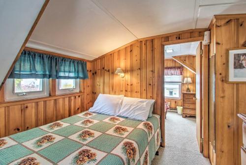 a bedroom with a bed in a room with wooden walls at Sebago Lake Cottage with Patio and Beach Access! in North Sebago