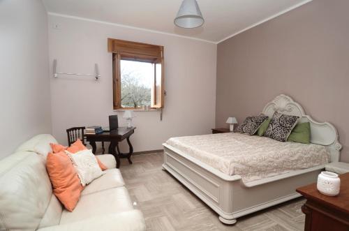 a bedroom with a bed and a couch at Villa Il Giovane Alloro in Martina Franca