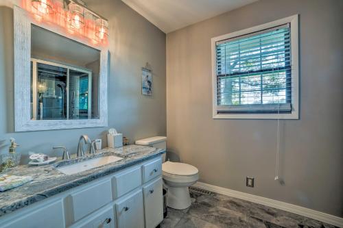 a bathroom with a toilet and a sink and a mirror at Calvert City Home, 8 Miles to Kentucky Lake! in Calvert City