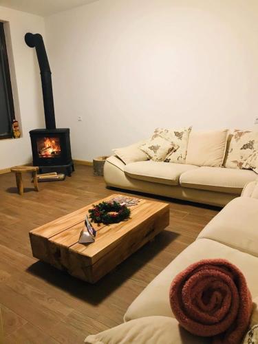 a living room with a coffee table and a fireplace at Beko’s garden Inn in Mestia