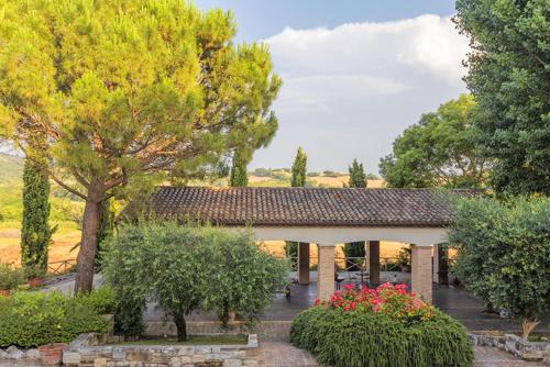a building with trees and flowers in a yard at Rustico del Conero in Camerano