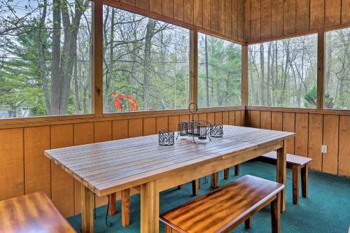 a wooden table and benches in a room with windows at 1 Mi to Hideout Ski Lake Ariel Home with Fire Pit in Lake Ariel