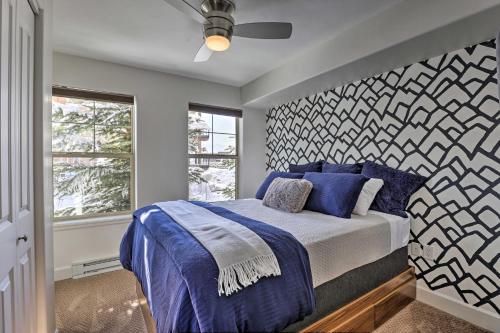 a bedroom with a bed with blue pillows and a wall at Wildhorse Meadows Studio with Resort Gondola Access! in Steamboat Springs
