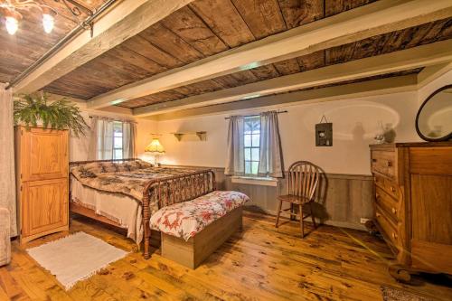 um quarto com uma cama, uma cadeira e uma cómoda em Remote 1901 Studio Cabin with Loft - Pets Allowed! em Allenwood