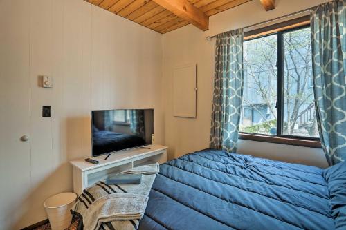 a bedroom with a bed and a flat screen tv at 1 Mi to Hideout Ski Lake Ariel Home with Fire Pit in Lake Ariel
