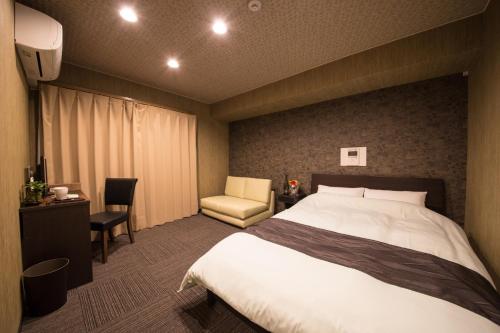 a hotel room with a bed and a chair at Osaka - Hotel / Vacation STAY 65245 in Osaka