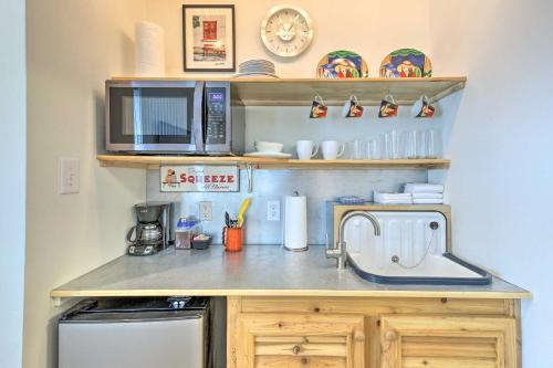 a kitchen counter with a microwave and a sink at Walk to Beach from Chic Old Town Apartment with Yard in Bay Saint Louis