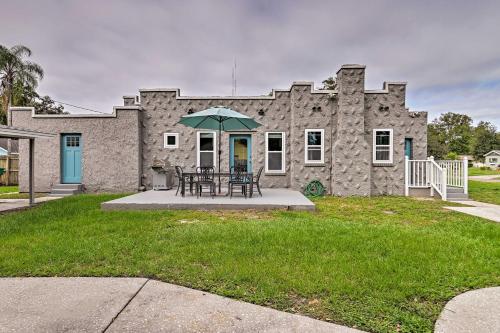 a table with an umbrella in front of a stone house at Walk to Dtwn Winter Garden Home with Patio in Orlando