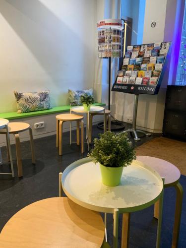 a room with tables and stools and a table with a plant at Youth Hostel - Central and Basic Universitat in Barcelona