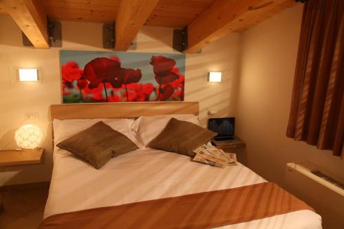 sypialnia z łóżkiem z obrazem na ścianie w obiekcie Residence Ilario Suite Hotel w mieście Riccione