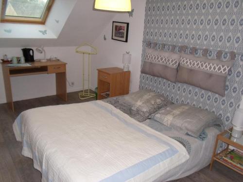une chambre avec un lit blanc et un bureau dans l'établissement chambre à la campagne, à Baulon