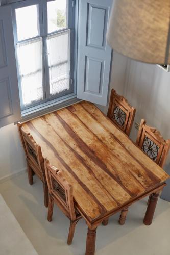 a wooden table with two chairs and a window at 9 Muses Exclusive Apartments in Grikos