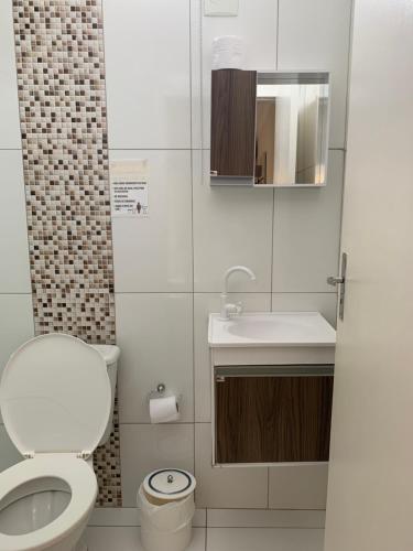 a small bathroom with a toilet and a sink at Pousada Vitória in Penha
