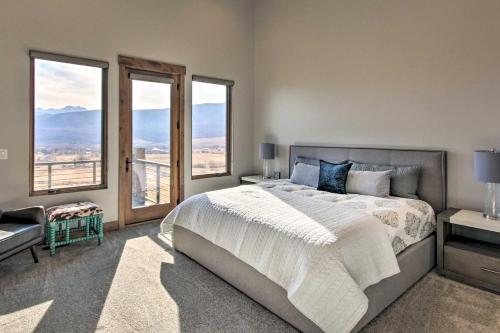 a bedroom with a large bed and large windows at Modern Mountain-View Townhome Less Than 7 Mi to Ski Resorts in Eden