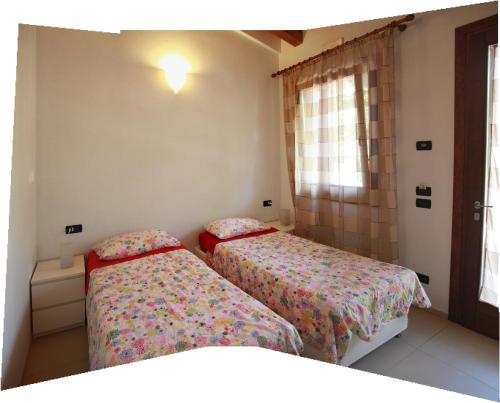 a bedroom with two beds and a window at Agriturismo Ca Noale in Teolo