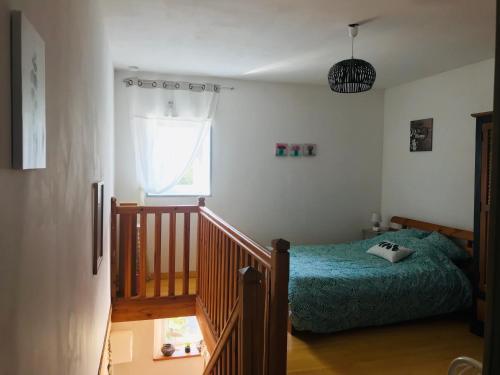 - une chambre avec un lit et un escalier avec une fenêtre dans l'établissement Entre Terre et Mer, à Réville