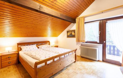 1 dormitorio con cama y techo de madera en Pension Schlossbergblick, en Simonswald