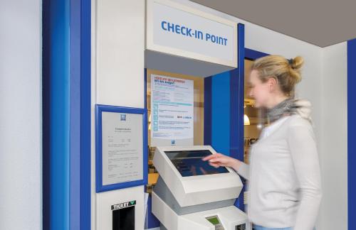 a woman is standing next to an atm machine at ibis budget Nürnberg City Messe in Nürnberg