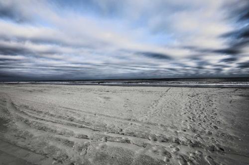 a beach with footprints in the sand and a cloudy sky at Steps to Ocean Breezy Myrtle Beach Bungalow! in Myrtle Beach