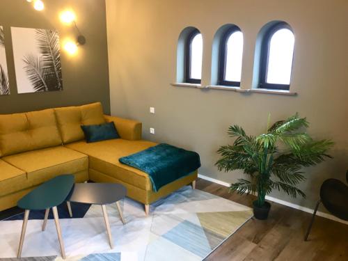 a living room with a yellow couch and two windows at Four in Koblenz