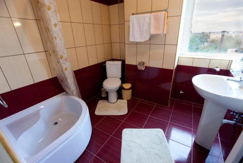 a bathroom with a tub and a toilet and a sink at Hotel La Gil in Bucharest