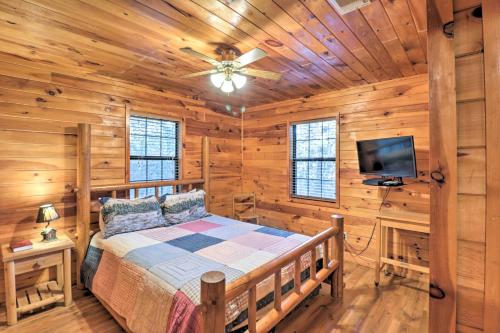 a bedroom with a bed in a log cabin at Starstruck Cabin with Spa 4 Mi to Broken Bow Lake! in Stephens Gap