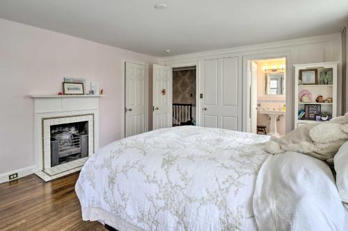 a white bedroom with a bed and a fireplace at Spacious Estate with Courtyard 2 Miles to Downtown! in Keene
