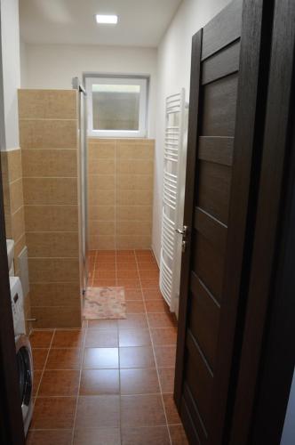 a bathroom with a shower and a tile floor at Ubytovanie Luky in Bojnice