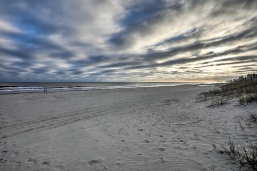 a beach with footprints in the sand under a cloudy sky at Steps to Ocean Breezy Myrtle Beach Bungalow! in Myrtle Beach