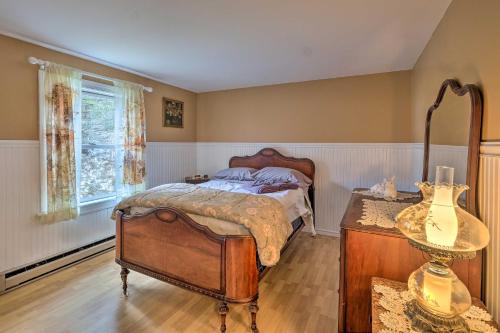 Schlafzimmer mit einem Bett, einem Tisch und einem Fenster in der Unterkunft Quiet Catskills Getaway with Deck-Panoramic Mtn Views in New Kingston