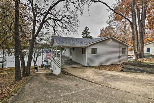 a white house with a driveway in front of it at Lily Pad Oasis with Dock on Lake of the Ozarks! in Gravois Mills