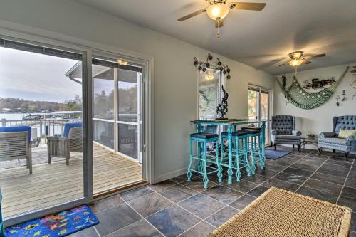 a living room with a table and a balcony at Lily Pad Oasis with Dock on Lake of the Ozarks! in Gravois Mills