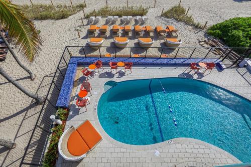 an overhead view of a swimming pool with chairs and tables at Ocean Treasure Beachside Suites in Fort Lauderdale