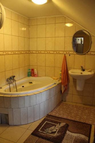 ein Badezimmer mit einer Badewanne und einem Waschbecken in der Unterkunft Dom na Zaciszu in Laliki