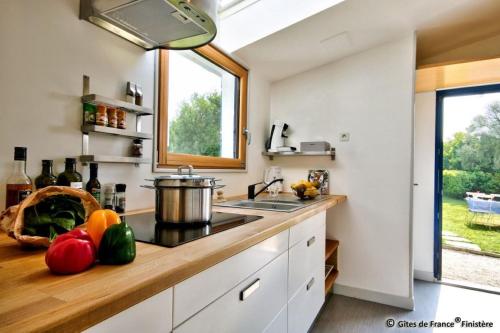 a kitchen with a counter with fruits and vegetables on it at Gîte Le pied à terre in Kerlouan
