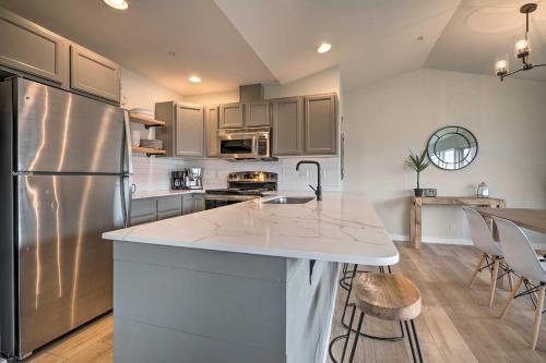 a kitchen with a stainless steel refrigerator and cabinets at Chic Chelan Condo with Balcony, Walk to Lake and Dtwn! in Chelan