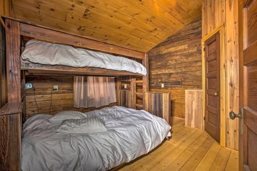 a bedroom with a bed in a wooden cabin at Scenic Log Cabin with Fire Pit and Stocked Creek! in Titusville