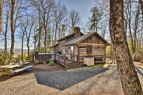 a log cabin in the woods with a picnic table at Cabin Near Boone with Hot Tub and Mountain Views in Fleetwood