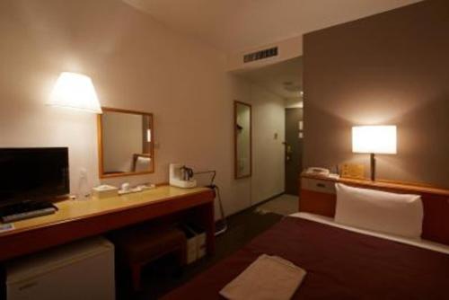 Pokój hotelowy z łóżkiem i biurkiem z lustrem w obiekcie Country Hotel Takayama - Vacation STAY 67704 w mieście Takayama