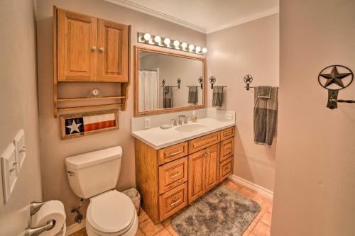 a bathroom with a toilet and a sink and a mirror at Casa de Samuel - Patio, Fountain and Outdoor Kitchen in Corpus Christi
