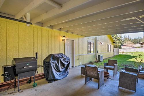 a screened in porch with a television and chairs at Coastal Retreat Near Redwoods and 2 Miles to Beach! in Crescent City